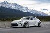 White sports car on a road with mountains in the background