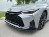 Close-up of the front end of a silver Lexus sedan parked outdoors on asphalt, showing the large black grille, headlights, and wheel.