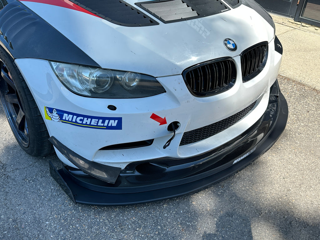 Close-up of a BMW car with a Michelin logo on a road.